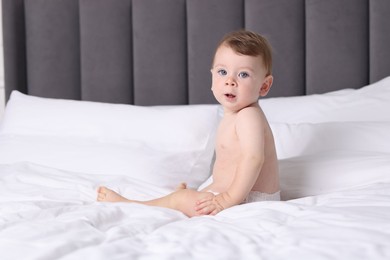 Photo of Cute little baby on bed at home, space for text