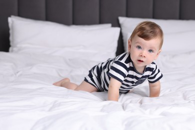 Photo of Cute little baby on bed at home, space for text
