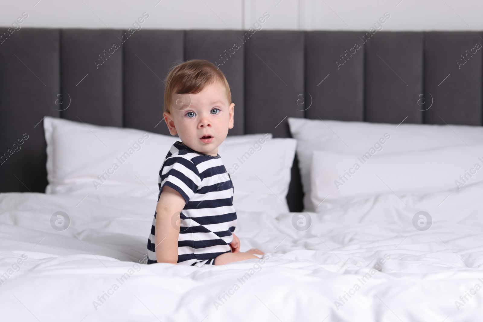 Photo of Cute little baby on bed at home, space for text