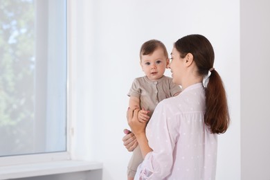 Photo of Mother with her cute little baby at home, space for text