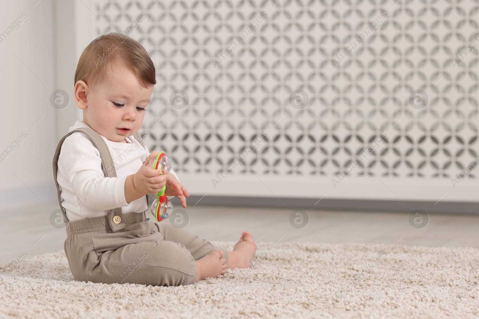 Photo of Cute little baby with toy on floor at home, space for text
