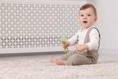 Photo of Cute little baby with toy on floor at home, space for text