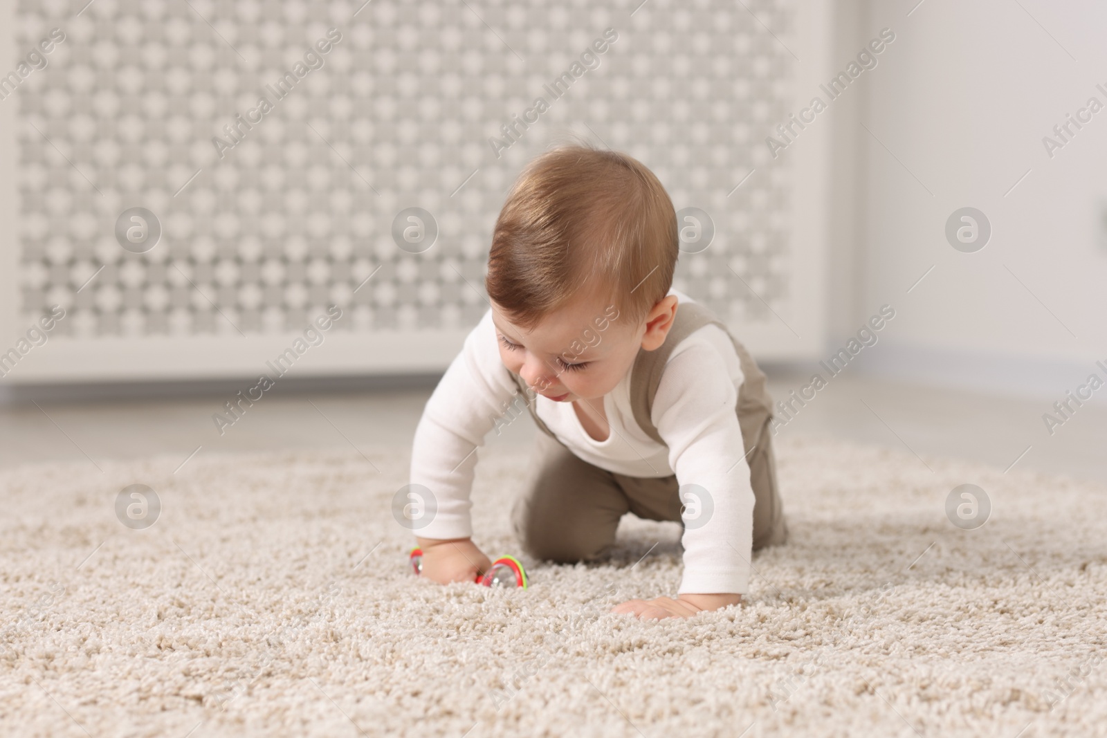 Photo of Cute little baby with toy on floor at home