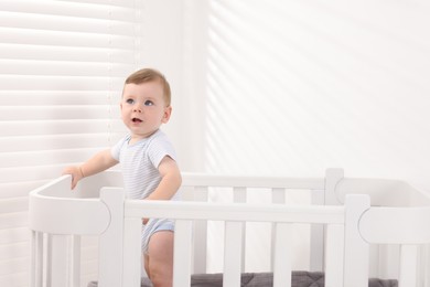 Photo of Cute little baby in crib at home