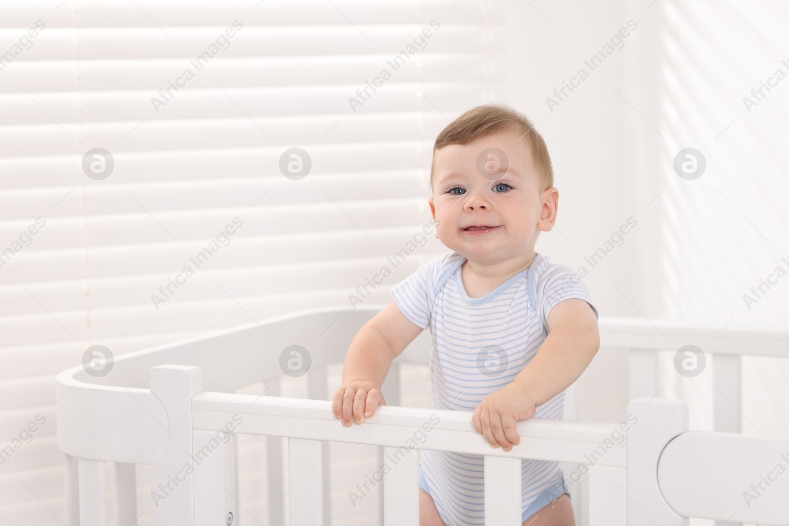 Photo of Cute little baby in crib at home