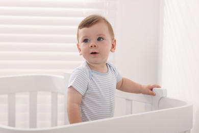 Photo of Cute little baby in crib at home