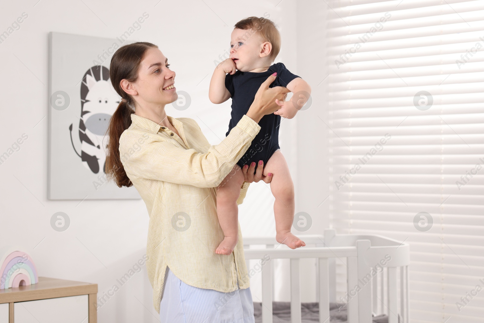 Photo of Mother with her cute little baby at home, space for text
