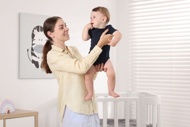 Photo of Mother with her cute little baby at home, space for text