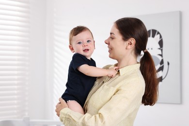 Photo of Mother with her cute little baby at home, space for text