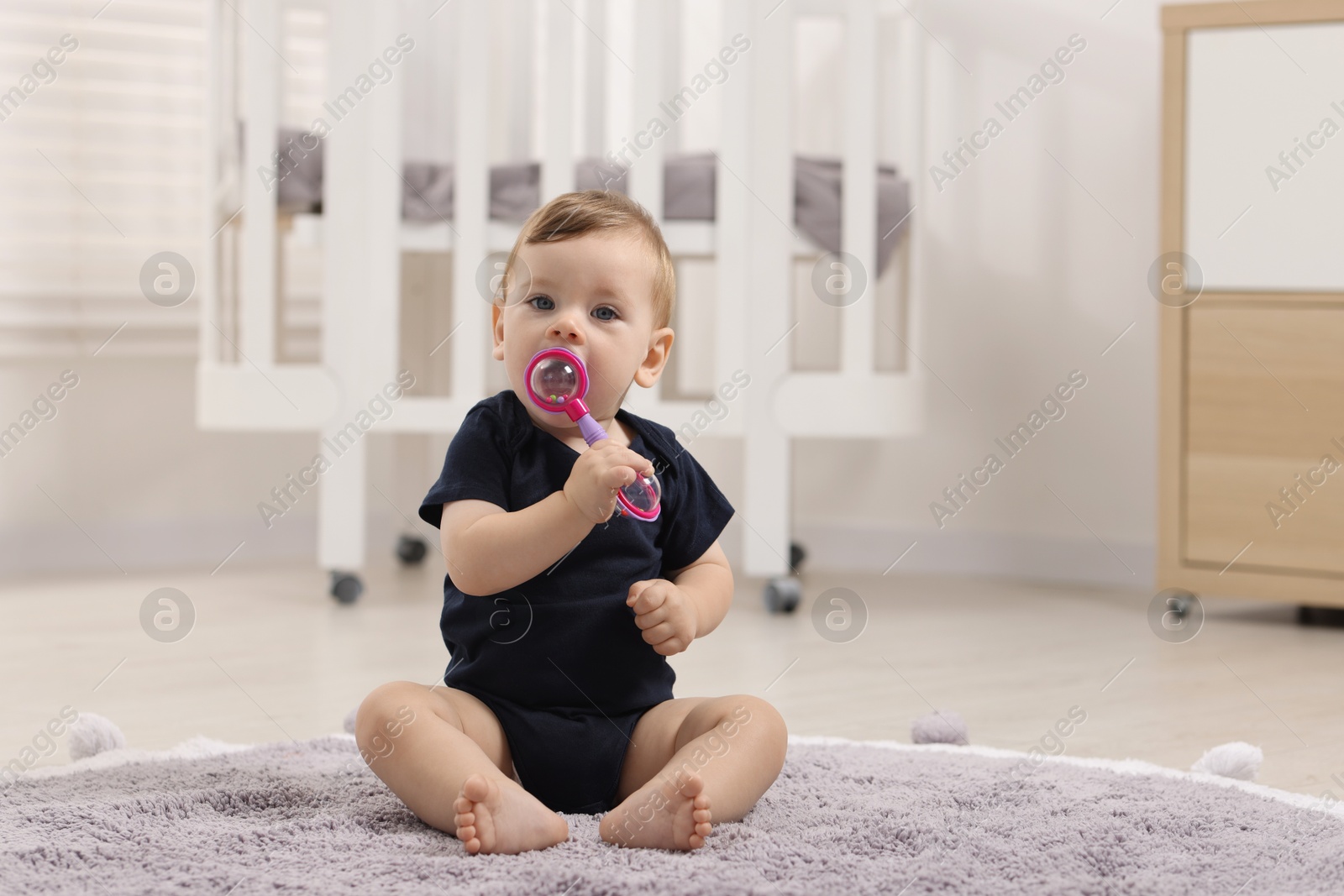 Photo of Cute little baby with toy on floor at home, space for text