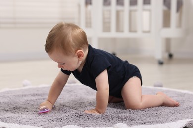 Photo of Cute little baby with toy on floor at home