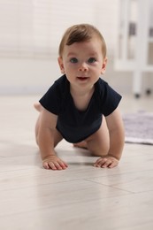 Photo of Cute little baby crawling on floor at home