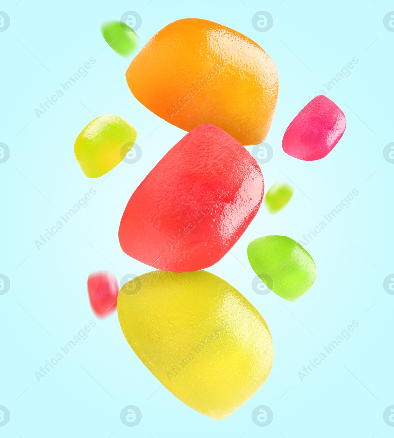 Image of Sweet jelly candies falling against light blue background