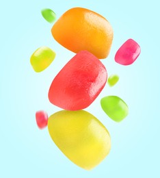 Image of Sweet jelly candies falling against light blue background