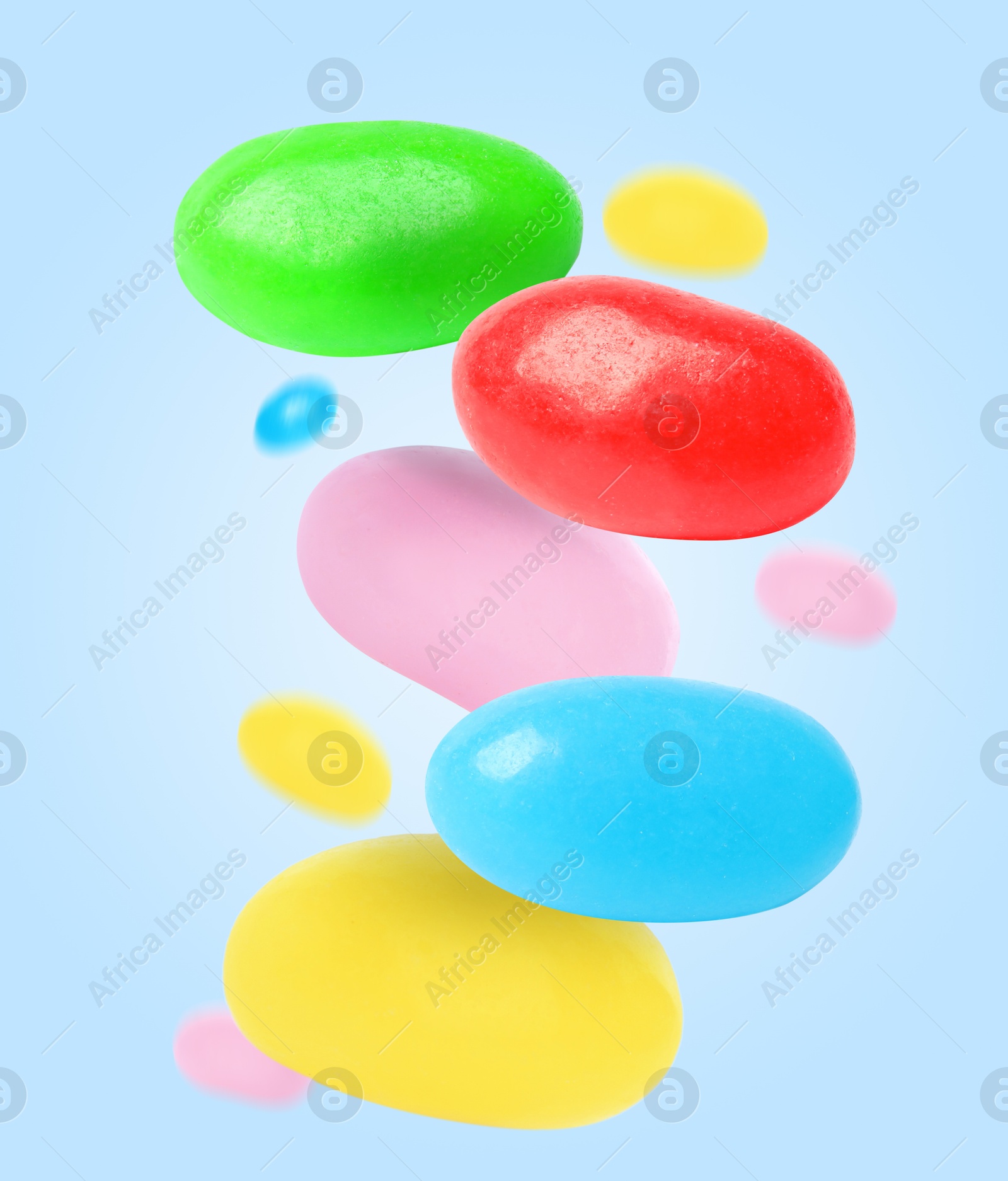 Image of Sweet jelly beans falling against light blue background