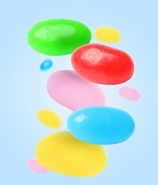 Image of Sweet jelly beans falling against light blue background