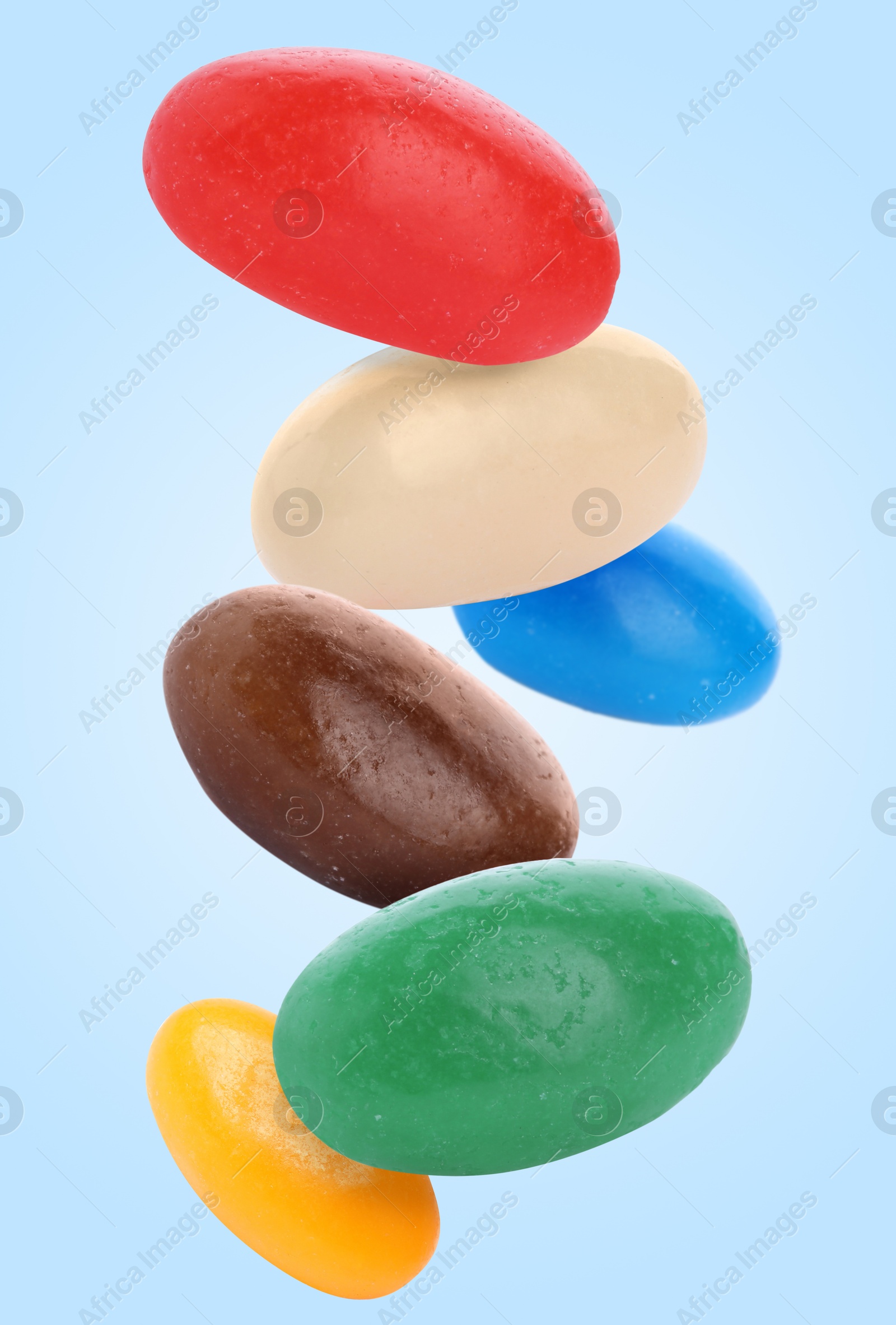 Image of Sweet jelly beans falling against light blue background