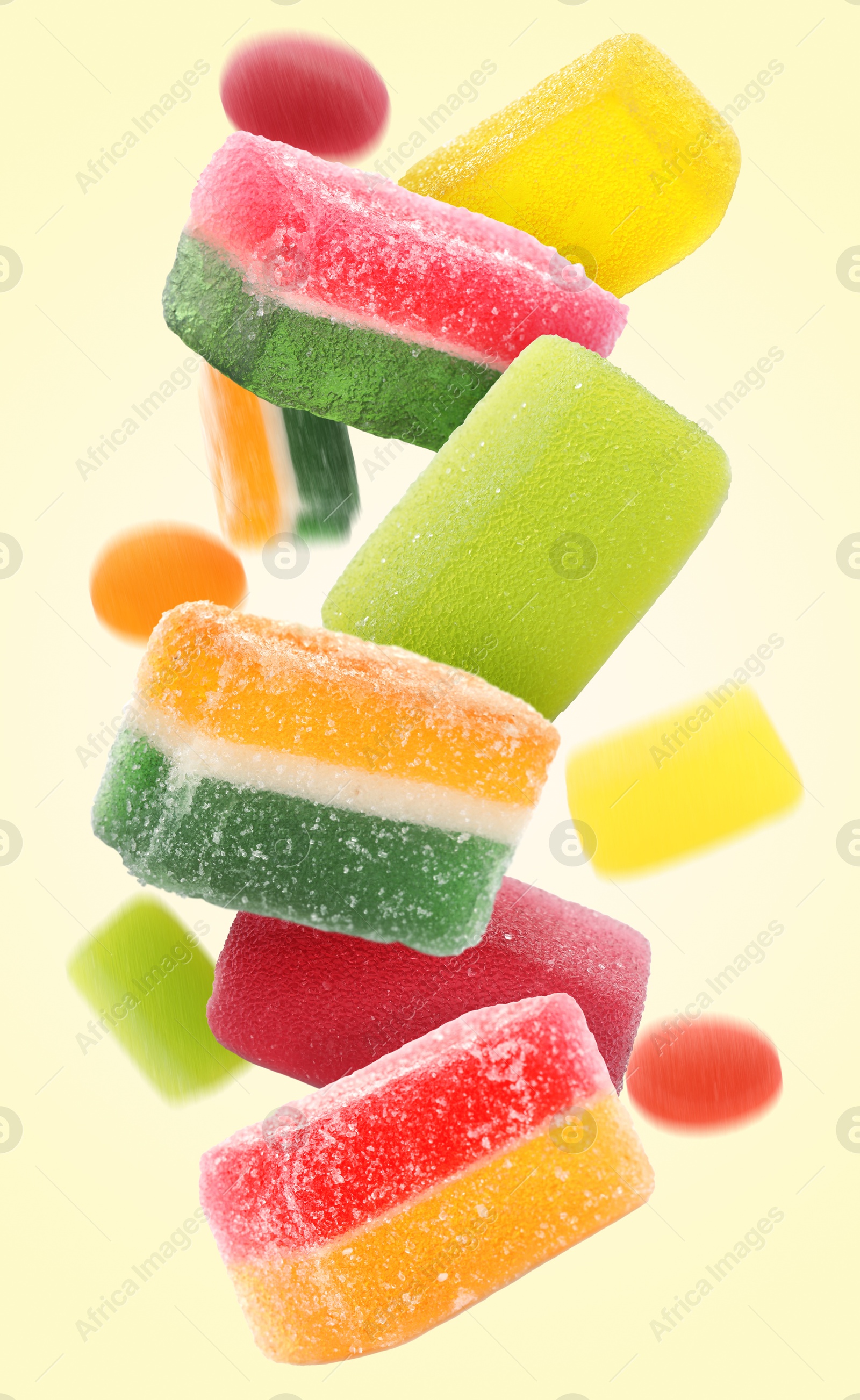 Image of Sweet jelly candies falling against beige background