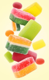 Image of Sweet jelly candies falling against beige background