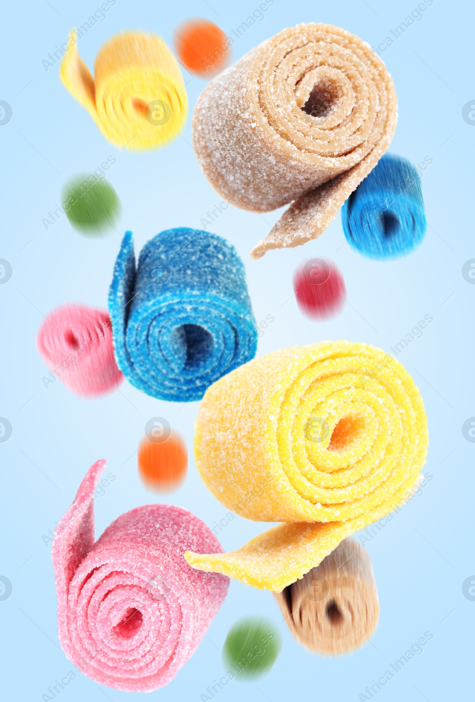 Image of Sweet jelly candies falling against light blue background