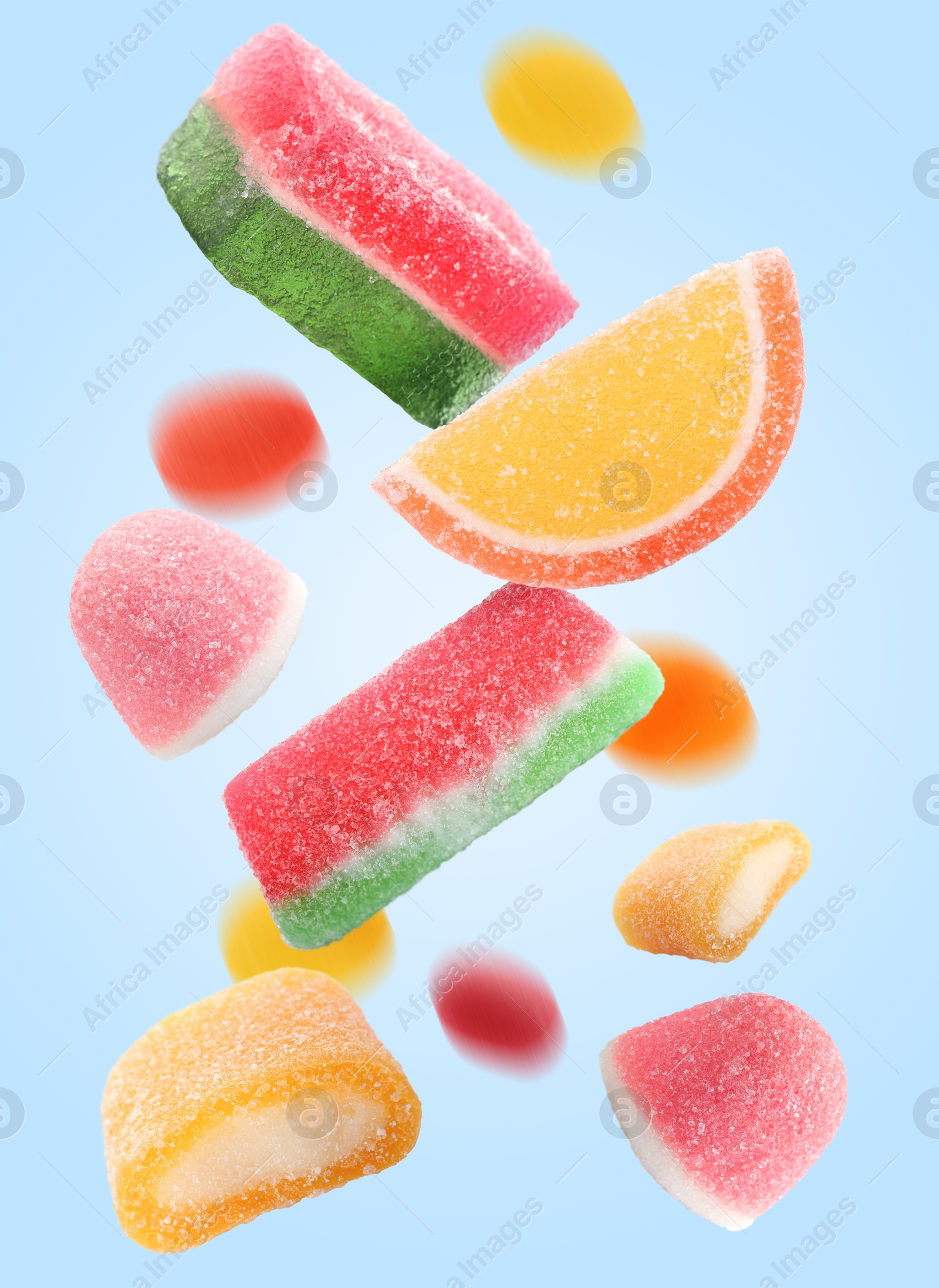 Image of Sweet jelly candies falling against light blue background