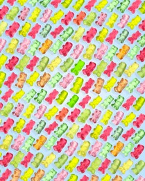 Image of Pattern of sweet gummy bears on light blue background. Jelly candies