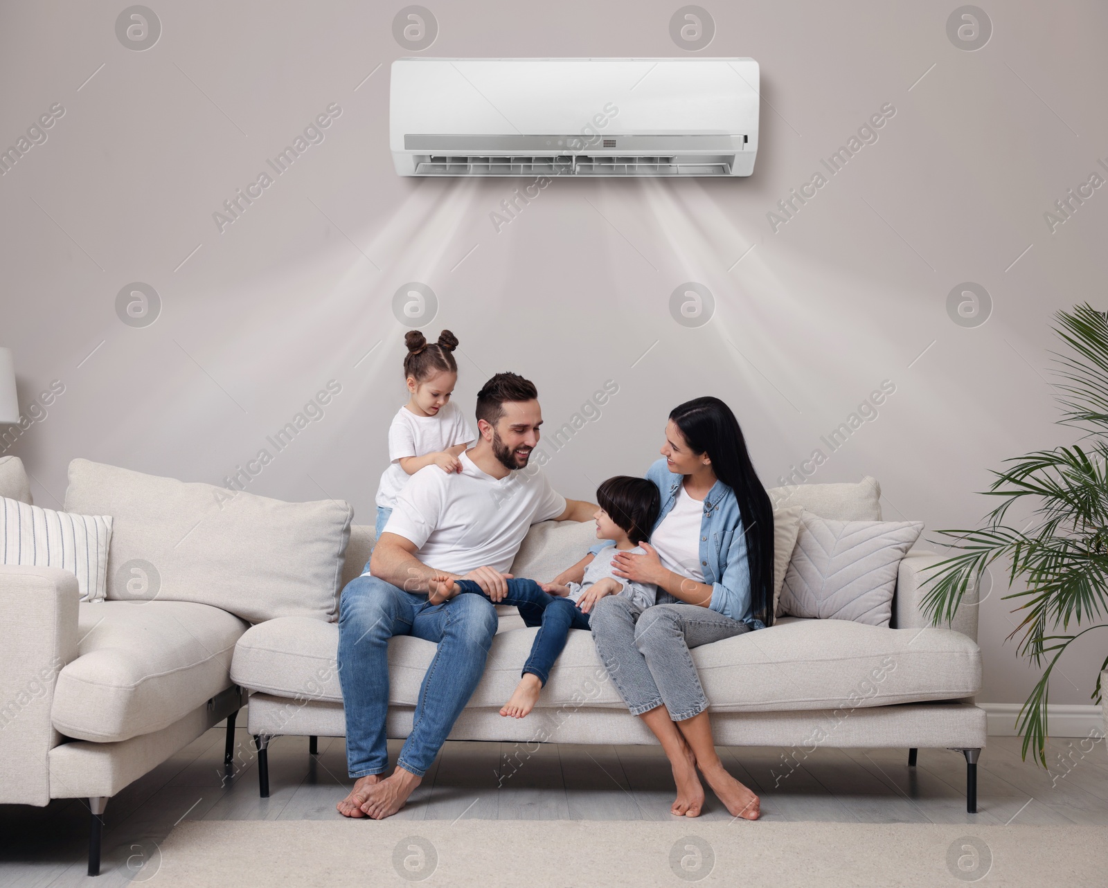 Happy family on sofa in living room. Air conditioner keeping comfortable temperature in room Image of Happy family on sofa in living room. Air conditioner keeping comfortable temperature in room