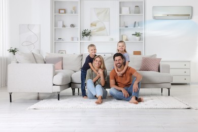 Image of Happy family with children on soft rug at home. Air conditioner keeping comfortable temperature in room