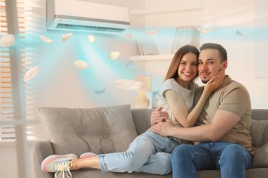 Image of Happy couple on sofa at home. Air conditioner keeping comfortable temperature in room
