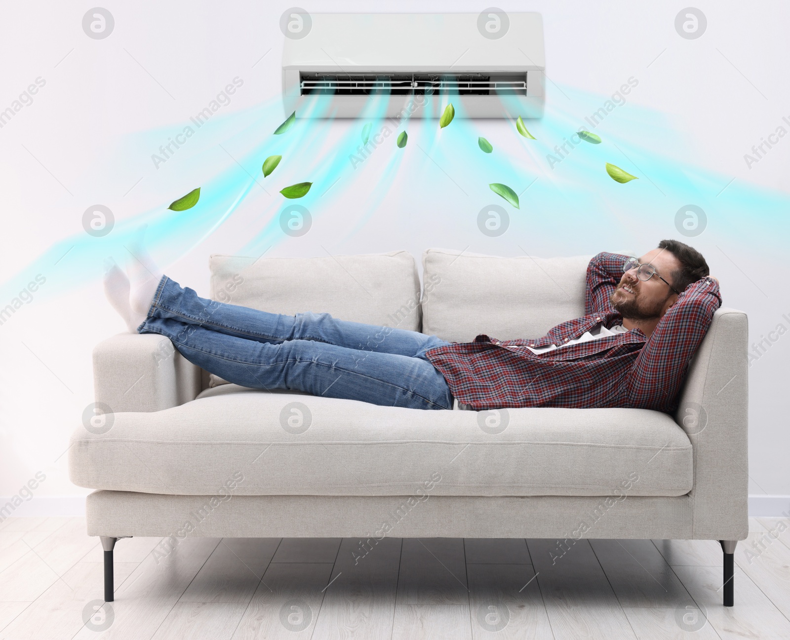 Image of Happy man relaxing on sofa at home. Air conditioner keeping comfortable temperature in room