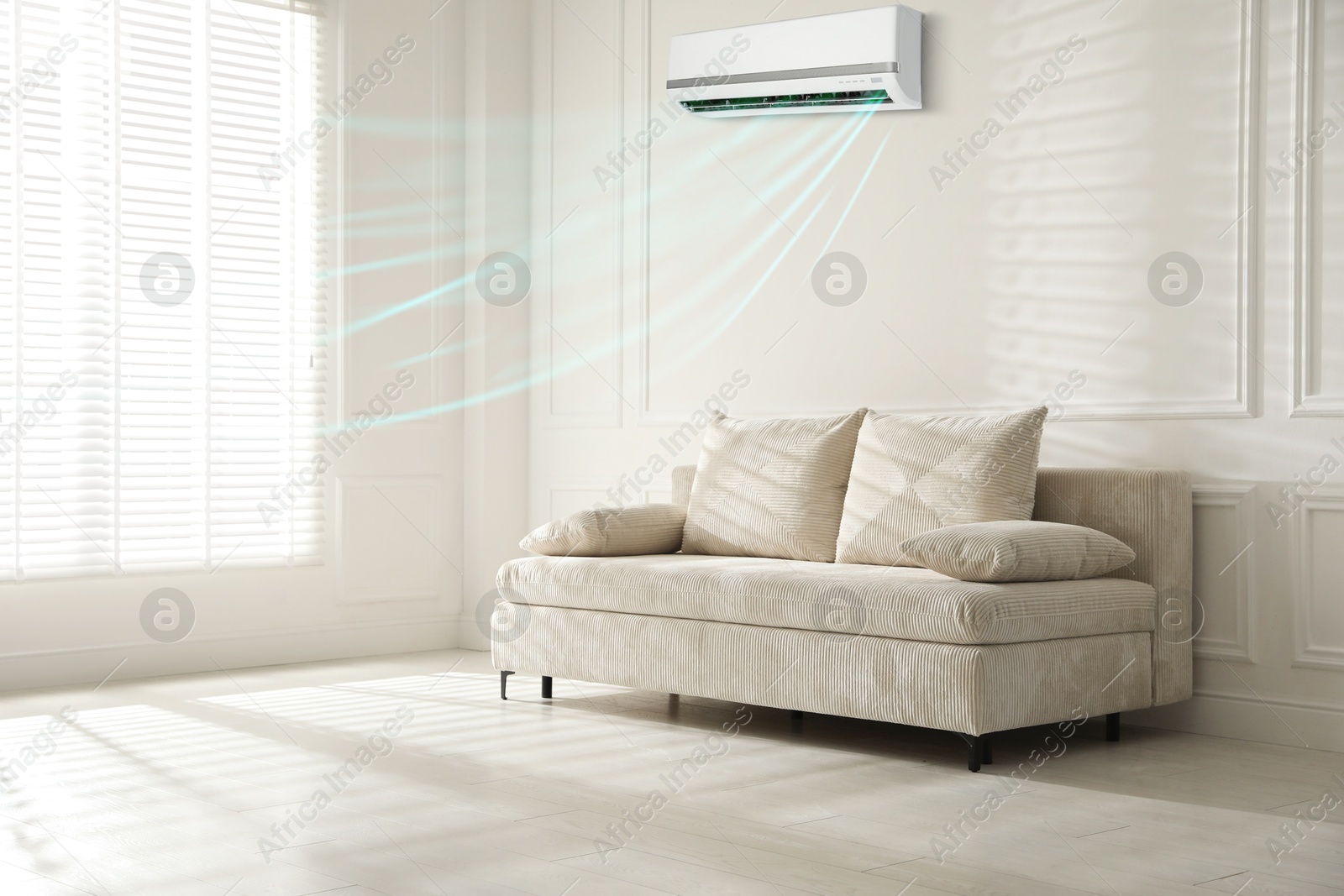 Sofa with pillows in living room. Air conditioner keeping comfortable temperature indoors Image of Sofa with pillows in living room. Air conditioner keeping comfortable temperature indoors