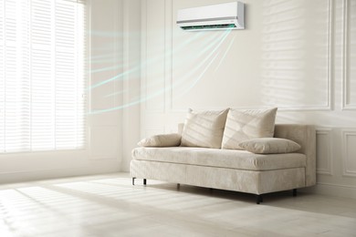 Image of Sofa with pillows in living room. Air conditioner keeping comfortable temperature indoors