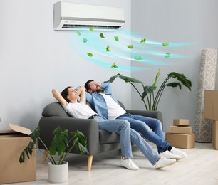 Image of Happy couple resting on couch at home. Air conditioner keeping comfortable temperature in room