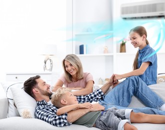 Image of Happy family spending time together on sofa at home. Air conditioner keeping comfortable temperature in room