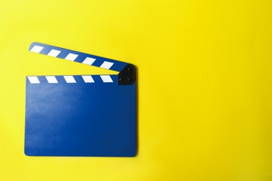 Image of Blue clapper board on yellow background, top view with space for text. Film industry
