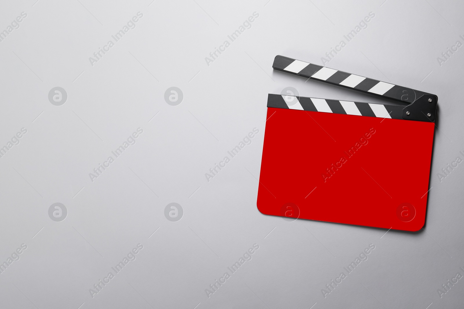 Image of Red clapperboard on grey background, top view with space for text. Film industry