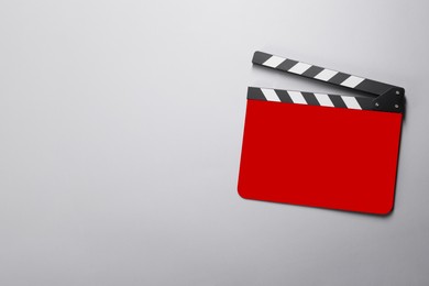 Image of Red clapperboard on grey background, top view with space for text. Film industry
