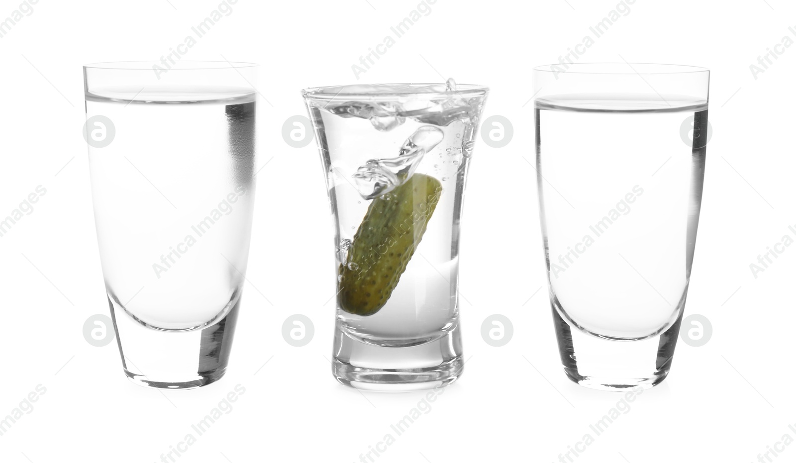 Image of Vodka in shot glasses and one with pickle inside isolated on white
