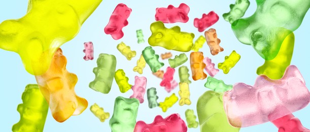 Image of Gummy bears in air against light blue background, banner design. Jelly candies