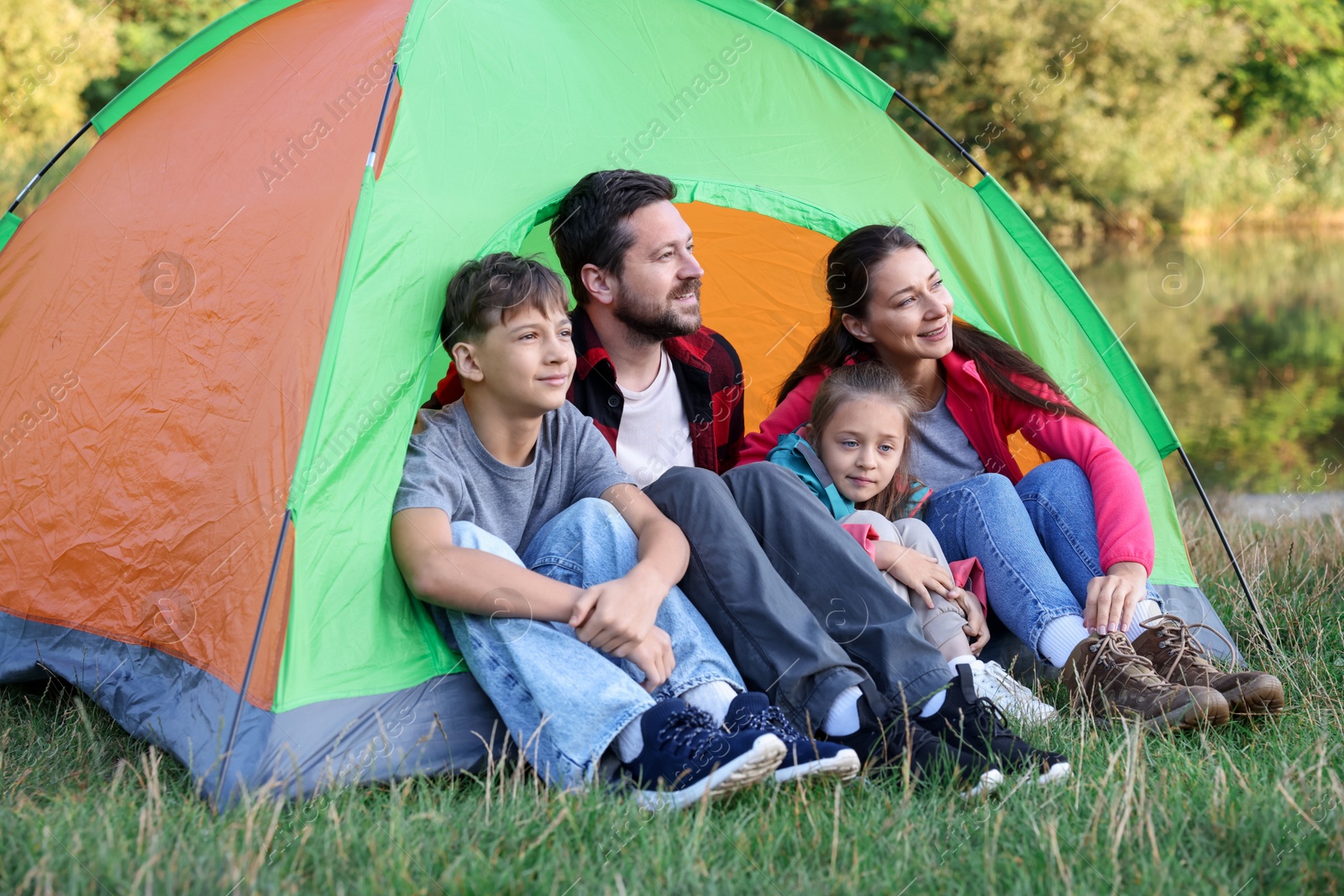 Photo of Happy family spending time together with camping tent outdoors