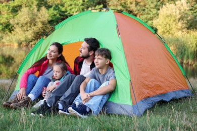 Photo of Happy family spending time together with camping tent outdoors