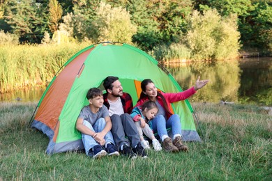 Photo of Happy family spending time together with camping tent outdoors