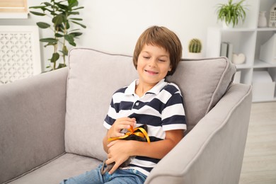 Photo of Dreams come true. Happy boy with pet rat on armchair at home