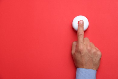 Photo of Man pressing button on red background, top view. Space for text