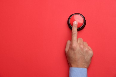 Photo of Man pressing button on red background, top view. Space for text