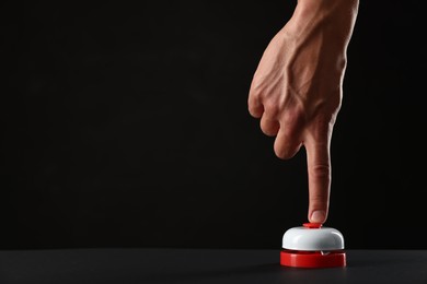 Photo of Man pressing button on black background, closeup. Space for text