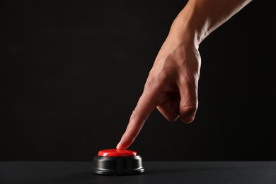 Photo of Man pressing button on black background, closeup. Space for text
