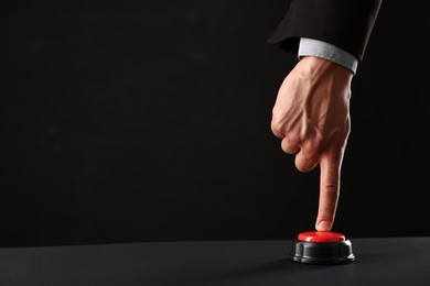 Photo of Man pressing button on black background, closeup. Space for text