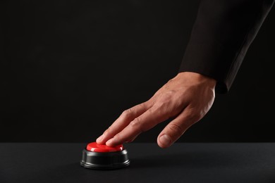 Photo of Man pressing button on black background, closeup. Space for text