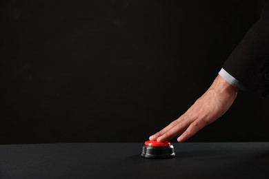 Photo of Man pressing button on black background, closeup. Space for text